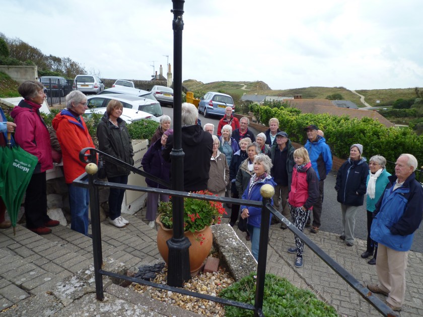 Group receiving briefing outside west Lulworth House from Chris