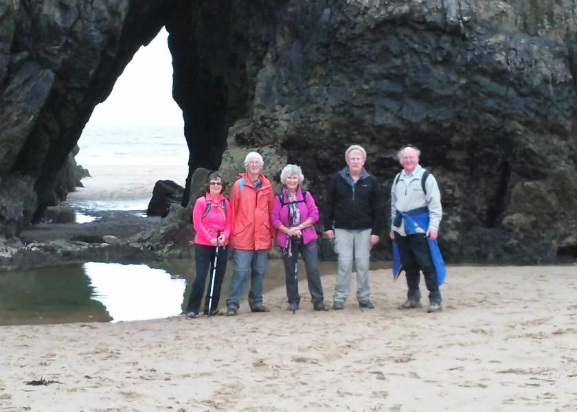 The group posing under the impressive archway on Three Cliffs beach.
