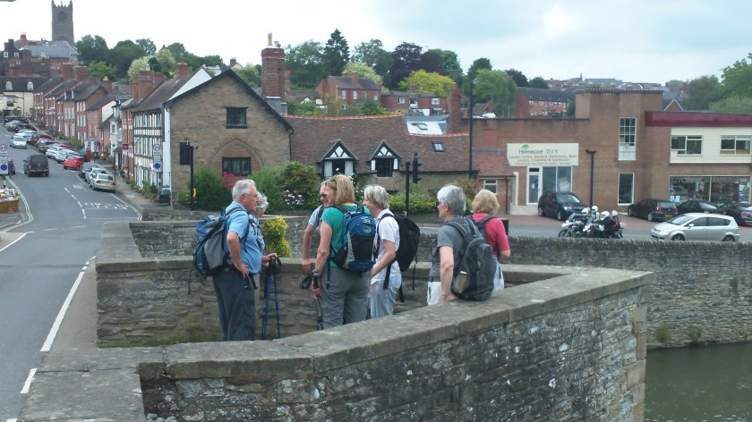 Group gather their breadth on bridge over river Teme