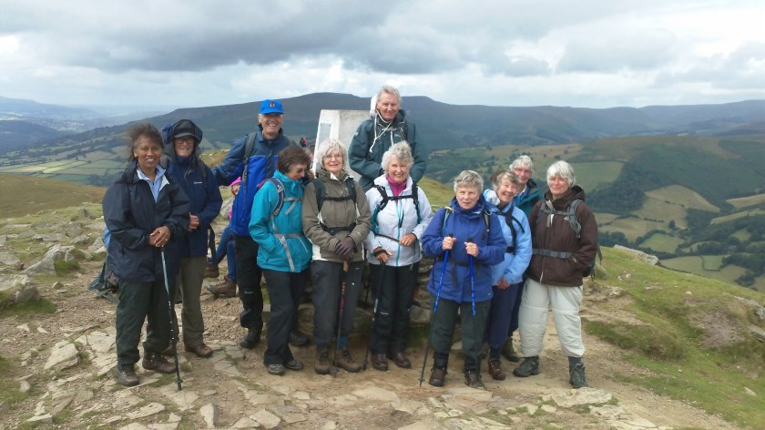 Whole group (minus photographer Neville) now in wet weather gear by the Trig Point (596m) on top of Sugar Loaf