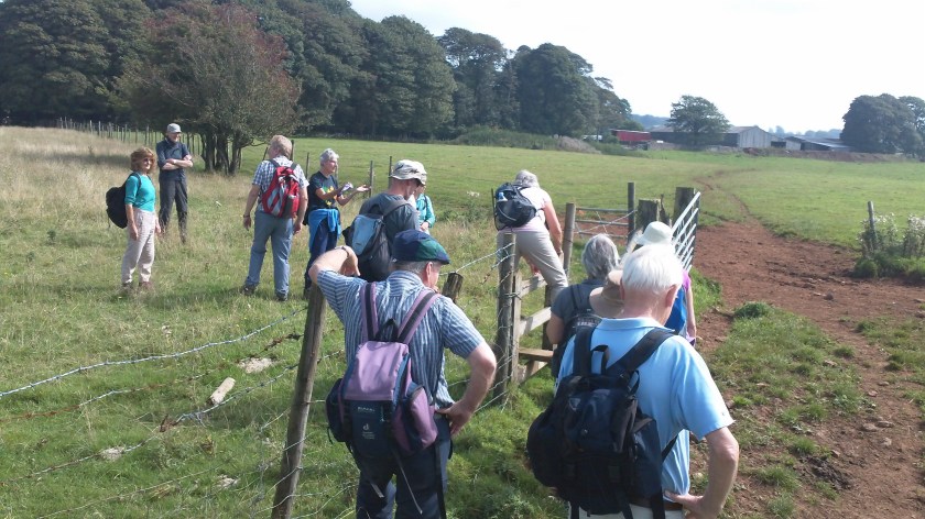 Group climbing over stile up on Mendips Hills plateau