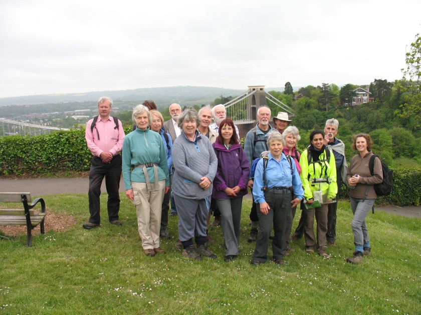 Group posing for photo with the Suspension Bridge in the background.